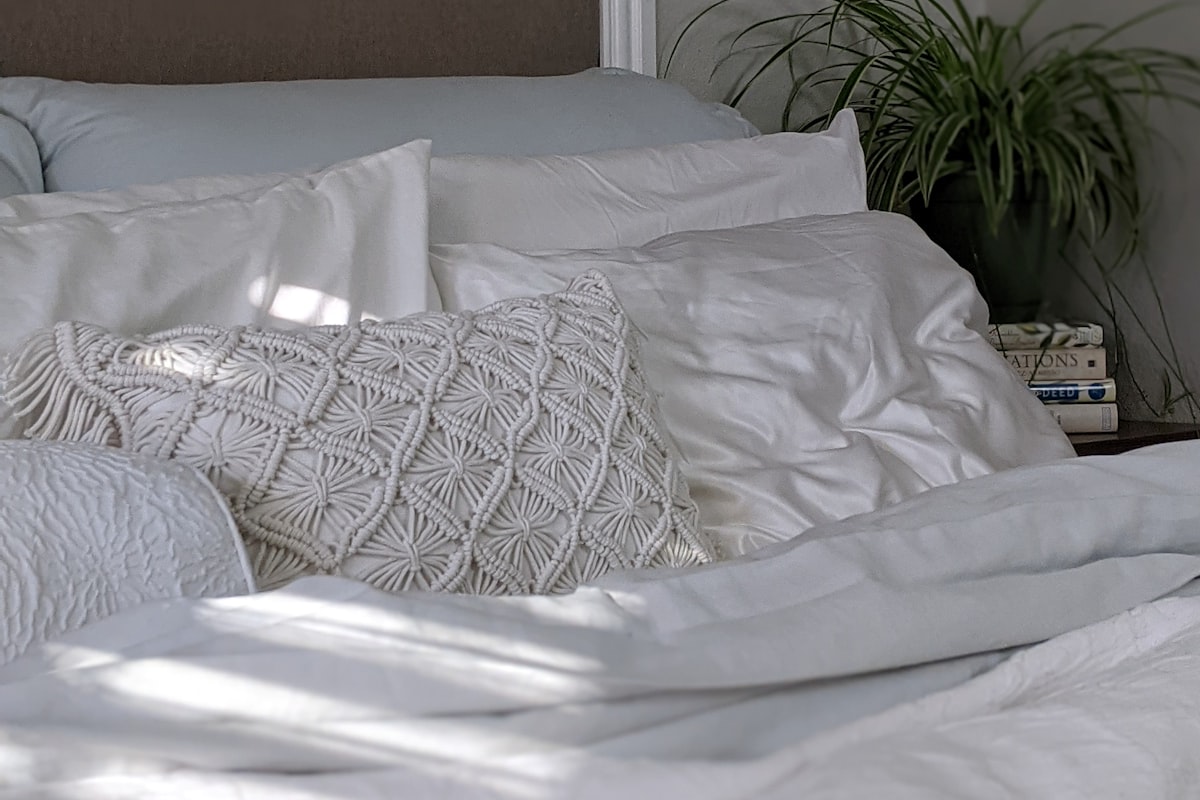 Bed dressed in white and grey linen